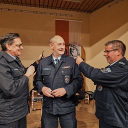 Die stellvertretenden Wehrleiter Dirk Minor und Andreas Becker nehmen Stephan Christ die Dienstgradabzeichen ab